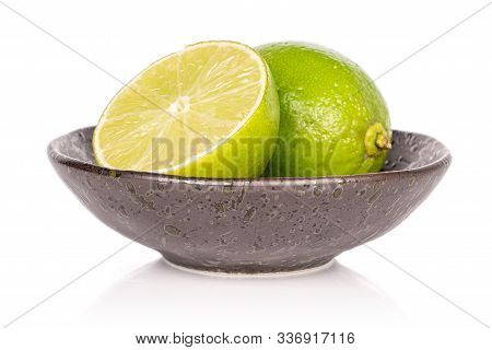 Group Of One Whole One Half Of Sour Green Lime In Glazed Bowl Isolated On White Background