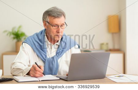 No Ageism. Elderly Businessman Using Laptop And Taking Notes Working Sitting In Modern Office. Selec