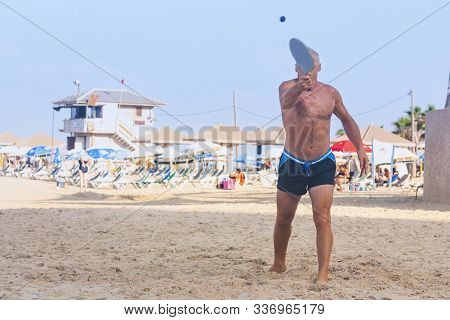 Adult Male Playing Matkot On The Beach