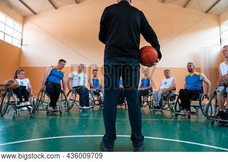 selector I explain new tactics to basketball players in wheelchairs, players sit in wheelchairs listening to the selector