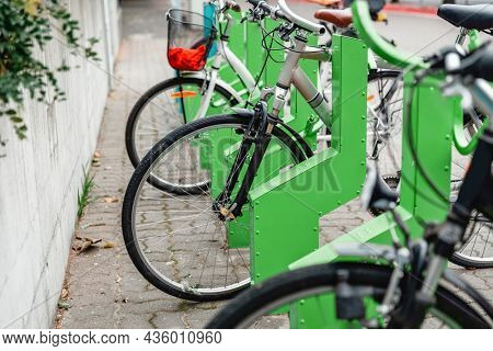 transport and sustainability concept - bicycles at electric bike charging station on city street