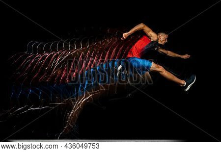 Full-length Portrait Of Young Man, Professional Athlete Jumping Over Barrier Isolated Over Black Bac