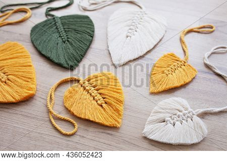 Macrame Leaves In Yellow, Green  And Natural Color On The Wooden Background. Cotton Rope Decor Macra