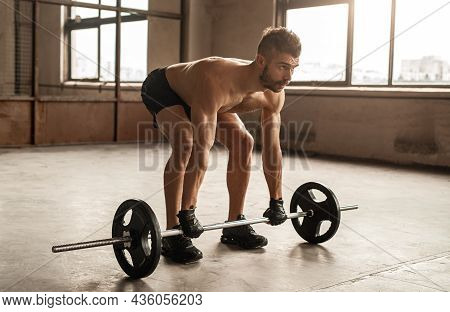 Full Length Of Concentrated Athletic Shirtless Bearded Male In Weightlifting Gloves Deadlifting Heav