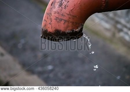 Water Droplets Flow From Old Rusty Pipe. Water Scarcity On Planet. Concept Of Land Pollution And Fos