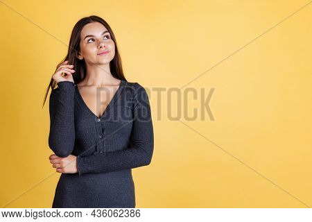 Cropped Portrait Of Young Beautiful Caucasian Girl Thougtfully Looking Away Isolated Over Yellow Bac