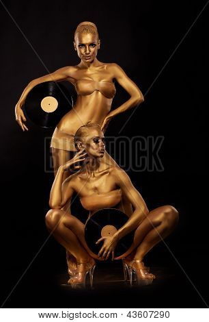 Zlaté Bodyart. Zbarvení. Zlatý ženy siluety s Retro Vinyl Records nad černou. Kreativní umění C