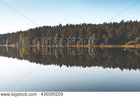 Fall Serene Landscape With Green And Yellow Woods, Its Reflection In Lake Water, Clear Blue Sky Hori