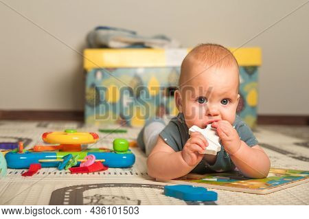 Baby 7 Months Old Baby Crawls And Plays On Floor With Toys. Newborn Care Concept, Teething, Colic.
