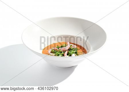 Summer Spanish soup gazpacho with shrimp and rocket salad isolated on white background. Healthy cold tomato soup with prawns. Clean eating for diet.Healthy food in restaurant menu. Seafood gazpacho