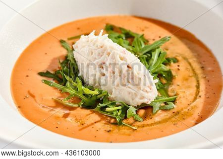 Summer Spanish soup gazpacho with crab meat and rucola isolated on white background. Delicious cold tomato soup with crab. Clean eating for diet.Healthy food in restaurant menu. Crab gazpacho