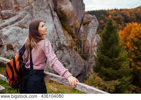 Woman Traveler With Backpack Stands By Rocks In Tustan In Autumn Carpathian Mountains. Tourism In Fa