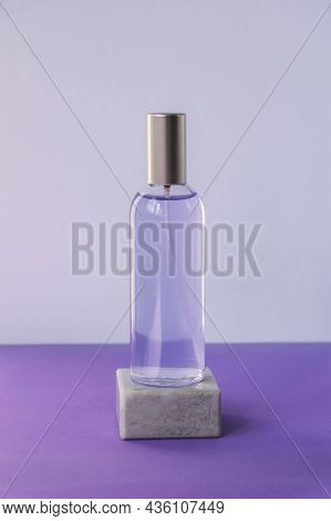 Cosmetic Water Or Hydrolat In Glass Bottle On Podium On Purple Tablle. Natural Cosmetics Concept. Mo