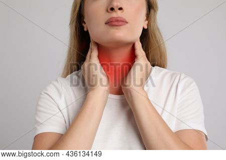 Young Woman Doing Thyroid Self Examination On Light Grey Background, Closeup