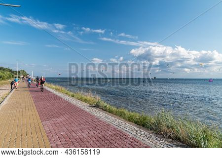 Jurata, Poland - July 20, 2021: Pedestrian And Bicycle Path And Kitesurfers In The Sea. Jurata Is A 