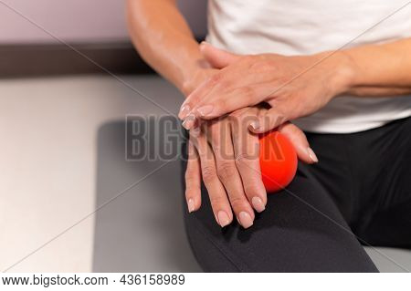 Sporty Slim Caucasian Woman Doing Self-massage Of The Thigh On Fitness Mat With Massage Ball Indoors