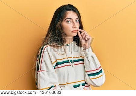 Young caucasian woman wearing casual clothes mouth and lips shut as zip with fingers. secret and silent, taboo talking 