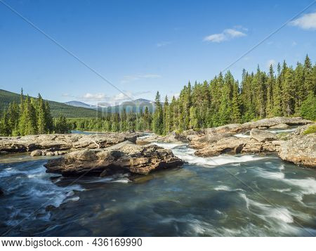 Beautiful Landscape With Long Exposure Water Stream And Cascade Of River Kamajokk, Boulders And Spru