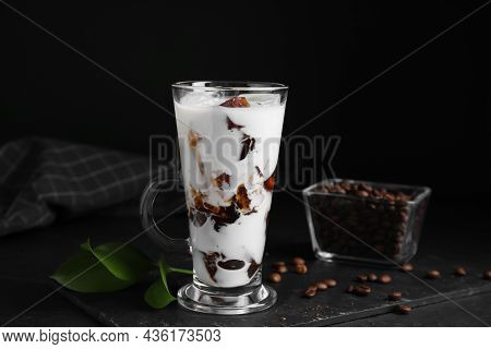 Glass Cup Of Milk With Delicious Grass Jelly And Coffee Beans On Black Table