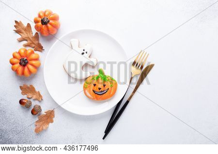 Halloween Table Setting With Gingerbread Cookies On White Plate And Cuterly On White Background. Bri
