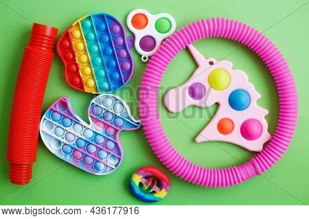 Colorful Antistress Sensory Fidget Toys On A Green Background
