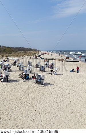 Zempin, Germany - April 20, 2014: People Enjoy The Sun At The Beach In The Roof Wickerd Chairs In Us