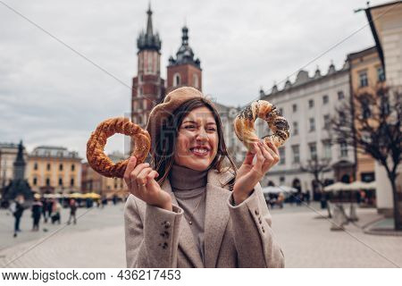 Tourist Woman Eating Bagel Obwarzanek Traditional Polish Cuisine Snack Waling On Market Square In Kr