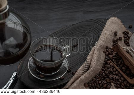Coffee Style, Cup Of Coffee And Coffee Beans Roating With Old Wooden Scoop And Coffee Beans Around O