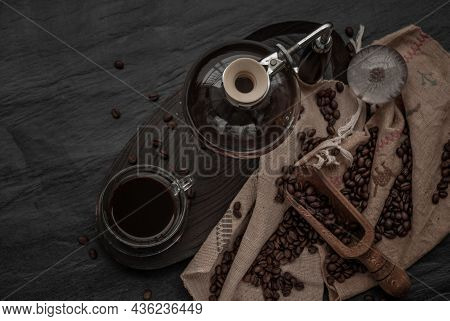 Coffee Style, Cup Of Coffee And Coffee Beans Roating With Old Wooden Scoop And Coffee Beans Around O
