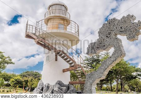 Uljin-eup, South Korea; September 19, 2021: Lighthouse On Cliff In Park Overlooking Hubo Seaport Und