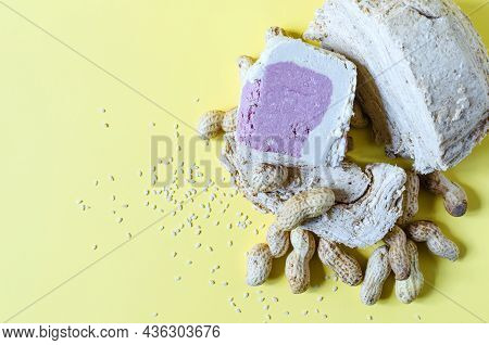 Peanut And Sesame Halva With A Decoration In The Form Of Peanuts And Sesame Seeds On A Yellow Backgr