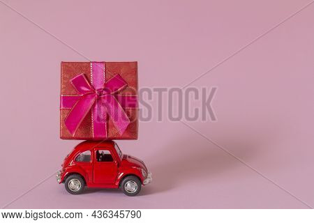 01.10.2021-zavyalovo, Russia.a Small Metal Red Retro Car With A Gift Box.the Concept Of Gift Deliver