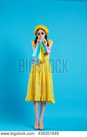 Cheerful Woman Yellow Dress Shopping Fun Blue Background