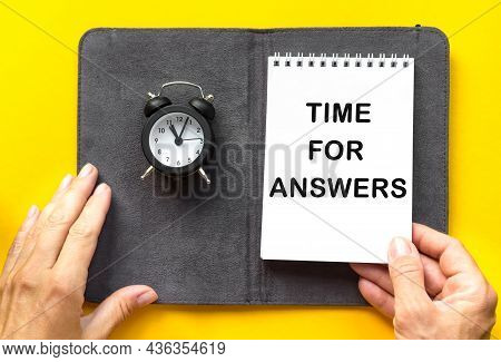 Time For Answer Women's Hand Holds A Small Alarm Clock Yellow Background