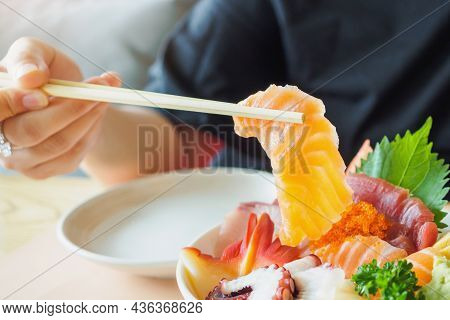 Salmon Slice In Chopsticks, Eating Sashimi Rice Bowl Chirashi Don Japanese Food