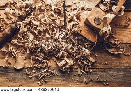 Plane jointer carpenter or joiner tool and wood shavings. Woodworking tools on wooden table. Carpentry workshop