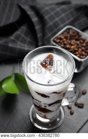 Glass Cup Of Milk With Delicious Grass Jelly And Coffee Beans On Black Table, Closeup