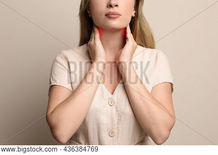 Young Woman Doing Thyroid Self Examination On Beige Background, Closeup