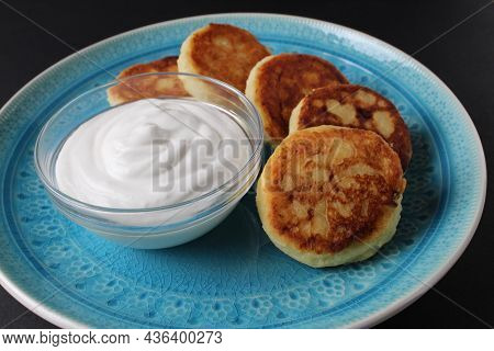 Breakfast Cheesecakes Curd Pancakes A Few Five Pieces Lie On A Large Blue Dish Plate With White Sauc