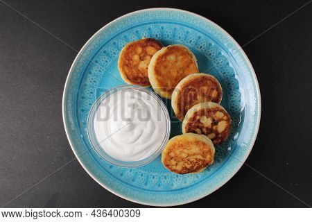 Breakfast Cheesecakes Curd Pancakes A Few Five Pieces Lie On A Large Blue Dish Plate With White Sauc