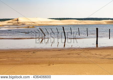Wood And Iron Fence Over Lake With Dunes