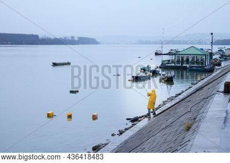 Belgrade, Serbia - January 31, 2016 Old Man, Fisherman Fishing On The Danube River During A Rainy Wi