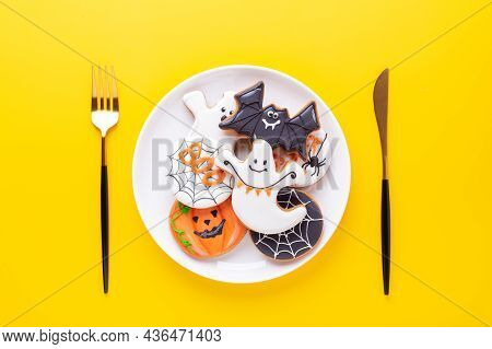 Halloween Table Setting With Gingerbread Cookies On White Plate And Cuterly On Yellow Background. Br