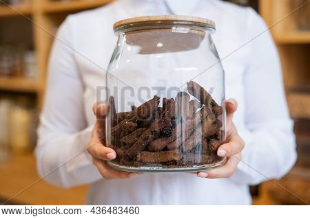 A Woman Holds Croutons In A Glass Jar. Eco Shop Without Plastic Waste.
