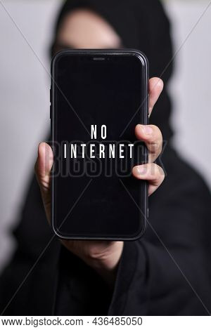 Muslim Woman Holding Smartphone With Text - No Internet. Symbol Internet Restrictions, Censorship Or