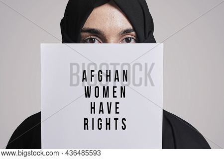 Muslim Woman Holding A Paper With Text - Afghan Women Have Rights. Muslim Woman In Traditional Hijab
