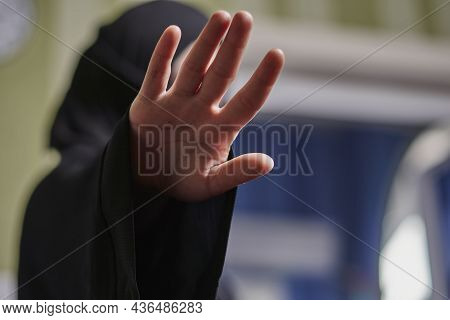 A Muslim Woman In Traditional Black Clothing Nikab Showing Stop Hand Gesture. Role Of Women In Islam