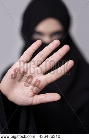 A Muslim Woman In Traditional Black Clothing Nikab Showing Stop Hand Gesture. Role Of Women In Islam