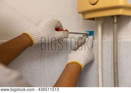 Worker Installing Floating Pipeline On The Wall In The Old Bathroom