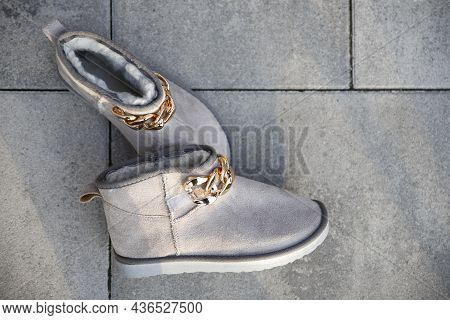 Fashionable Female Boots Resting On The Pavement